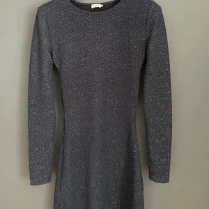 Glittrig klänning från Filippa K - En mörkblå glittrig klänning med figurgivande form från Filippa K. Glittrar i mörker. Insydd. 