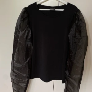 Svart festtopp - Superfin festlig tröja, topp från Gina Tricot, med ”puffärmar” i mesh/tyll,  endast använd fåtal gånger 🌟