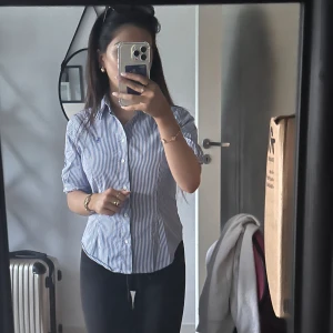 Ralph Lauren skjorta dam - Ljusblå randig skjorta av märket Ralph Lauren. Superfin modell som sitter smickrande i midjan med en ”utsvängd” botten. Sällan använd säljer därav vid bra bud💗