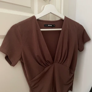 Brun festtopp från Bikbok - Brun v-ringad topp från BikBok. I nytt skick, och endast tvättad. Perfekt till sommar och fest 💗 