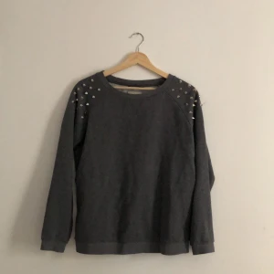 Tjocktröja med nitar - Tjocktröja med nitar på axlarna från märket Westhill REDBIRD. 