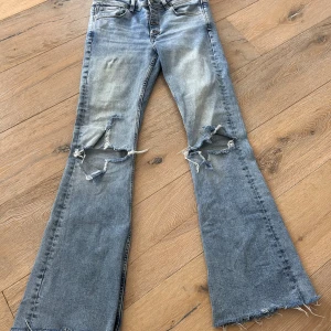 Mid waist Zara jeans - As snygga mid waist zara jeans. Säljer på grund av att de är för korta på mig. De har ett litet hål som syns på bild 4, det är dock enkelt att sy ihop det. Midjemått: 40 cm rakt över. Innerbenslängd: 79 cm.  Skriv privat om ni har frågor💗