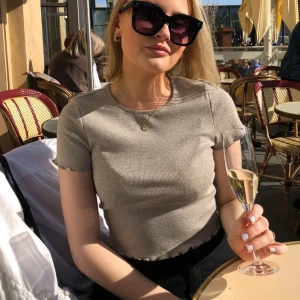 Glittrig croppad t-shirt  - Beige/silvrig topp från Gina Tricot, storlek S🤎