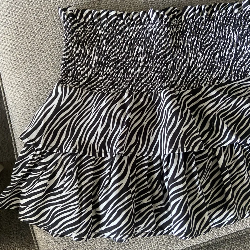 En zebramönstrqd volangkjol från Gina Tricot Young i storlek 158/164 men passar Xs/S.. Kjolar.
