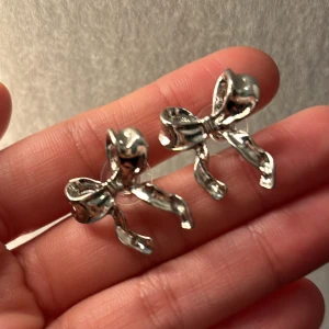 Söta örhängen  - Rosettformade örhängen, silverfärgade men håller färgen bra så länge man ej har dem i duschen! 