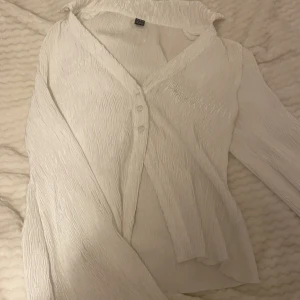 Topp - Elegant Topp i underbart material , storlek M med en slits vid magen säljs för 130 kr