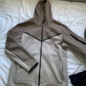 Nike Tech - Säljer min Nike Tech då den inte kommer till användning, den är i väldigt bra skick förutom en liten defekt som jag visar i tredje bilden. Defekten är verkligen inget som syns då den är på inre delen av armen som kommer va in mot kroppen🙏🏼