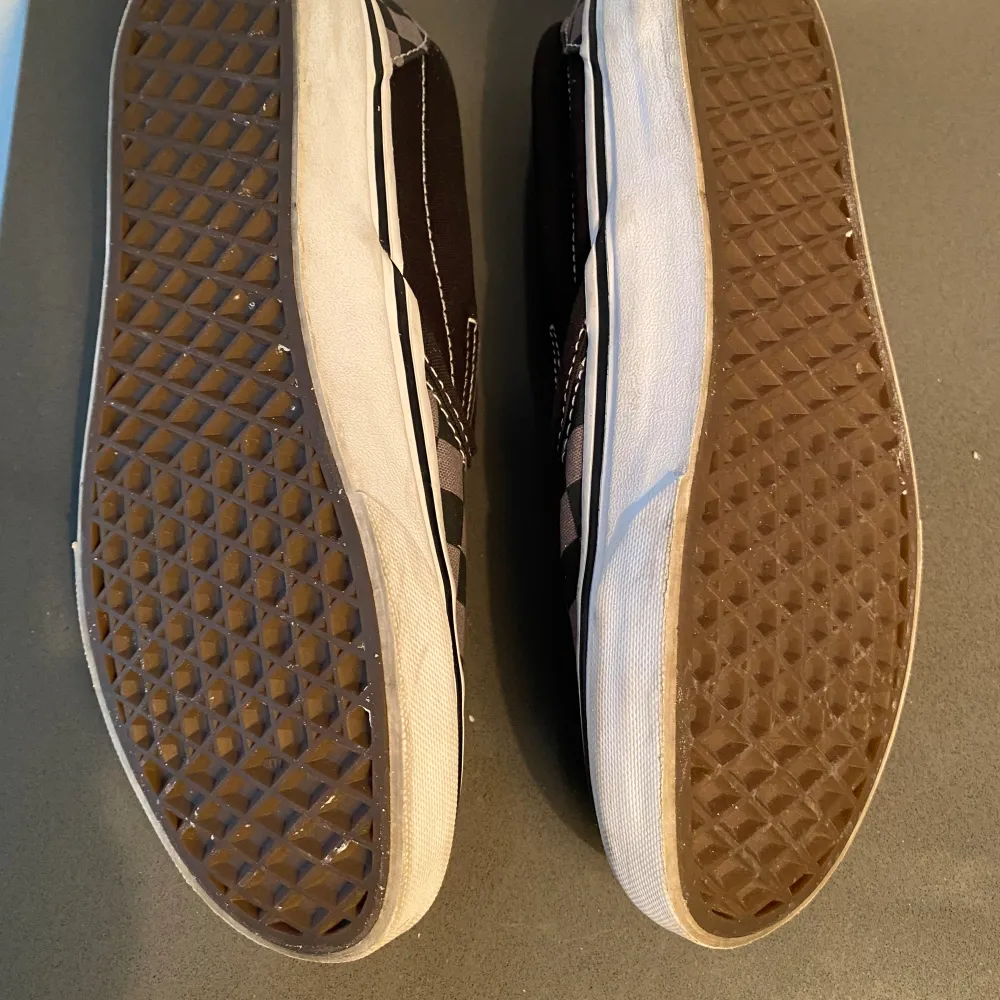 Grå och svarta Vans slip on sneaker i strl 37.  Endast använda 2-3 gånger och ser i princip nya ut förutom några grå/svarta märken på kanten på sulan.. Skor.