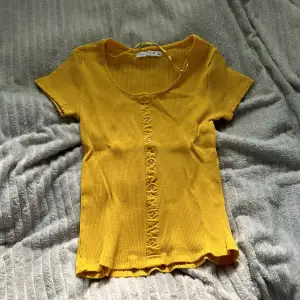 Gul t-shirt i storlek S men vet inte vad märket heter men ni ser namnet på bilden! Den är lite gul orange men väldigt fin till sommaren och är aldrig använd