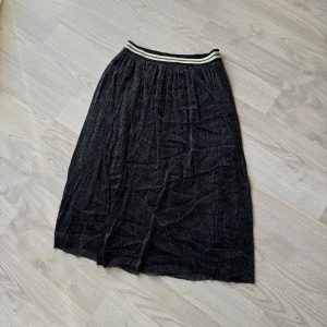 Glittrig kjol  - Glittrig kjol som går till knäna i storlek M. Knappt använd. Från JS Millennium. 