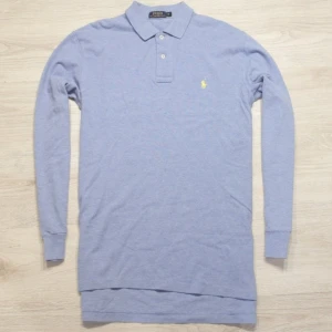 Långärmad Ralph Lauren piké  - I mycket gott skick Längd 75 cm, bredd 53cm*2. Ljusblå med gul häst