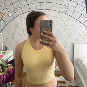 Träningstopp - Pastelgult criscross linne. Perfekt till gymmet!💕det är bara att fråga om ni vill ha fler bilder.