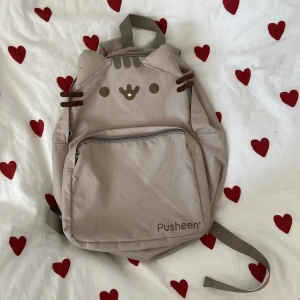 Pusheen ryggsäck - Pusheen ryggsäck från kawaii, ganska andvänd därför defekter som visas i bilderna, det går bara att ta 3 bilder men vid andra axelbandet är det också lite slitet och små fläckar på lilla facket, köpt för 400 men säljer ganska billigt pga defekterna🎀🐈‍⬛