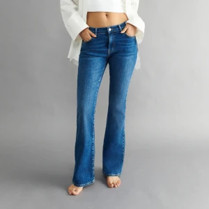 Blå Jeans Gina Tricot - Ett par blå lågmidjade jeans med bootcut ifrån Gina. Sparsamt använda!!💓