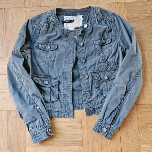 Jacka - Jättesnygg jacka med fina detaljer, perfekt till vår/sommar ❤️‍🔥 strolek 36 (S), skulle säga att den passar 34/XS bra också! 100% bomull, grön/grå färg 🩷 Hör gärna av dig vid frågor 🫶🏻