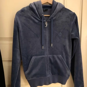 Juicy couture tracksuit  - Säljer settet tillsammans! Säljer pga att jag inte använde den så mycket. Den är i färgen grey/blue. Tröjan är i M och byxorna i S!!! Men tröjan sitter som S. Inga problem med dem men en av knapparna på snörena på byxorna har trillat av! ⭐️