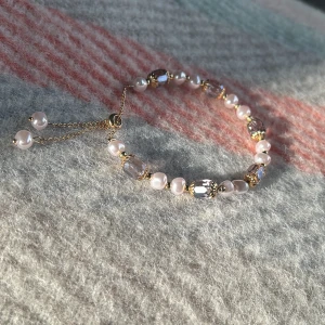 Armband Vintage - Snyggt armband, ställbart så det passar alla stl. I armbandet finns färger av lila, ljusrosa, guldfärg. Jättefint & prisvärt