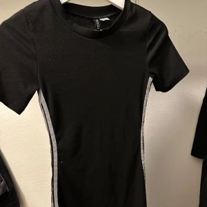 Klänning  - En svart klänning med silver detaljer vid sidan. Jag säljer denna för den är för liten för mig och inte kommer till användning. Storleken är Xs men är väldigt stretchig så om du har S och vill ha tajtare då är det också perfekt. 