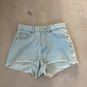 Jeanshorts - Ljusblåa jeanshorts från hm i strl 36/S. De är använda en sommar och inga defekter eller fläckar syns på plagget. Jag skulle säga att de är mittemellan hög och medelmidjat.