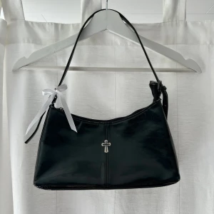 Svart handväska - Svart glansig väska i skinnimitation. Bredd: 30 cm. Djup: 6,5 cm. Höjd: 15 cm. Har tappat lite färg men inget som är jättemärkbart 🖤