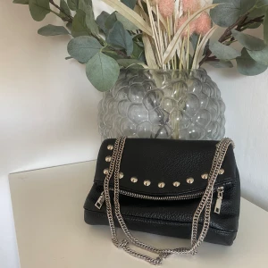 svart väska  - Säljer min svarta väska från Bershka, den är köpt på zalando för 200kr. Sparsamt använd men har lite slitningar, på kedjan, se bild, därav priset. Kedjan går att ha både som crossbody och som axelväska 🩷 Hör av dig om du har några funderingar! 