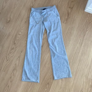 Grå Juicy Couture byxor storlek S <3 - Trendiga juicy couture byxor i ljusgrå! Normal i storleken, super skick 🤍 säljes pågrund av att jag inte använder så mycket längre. Har tagit upp sömmen längst ner för att göra byxorna längre, men kan sys upp igen om det önskas (se sista bild)