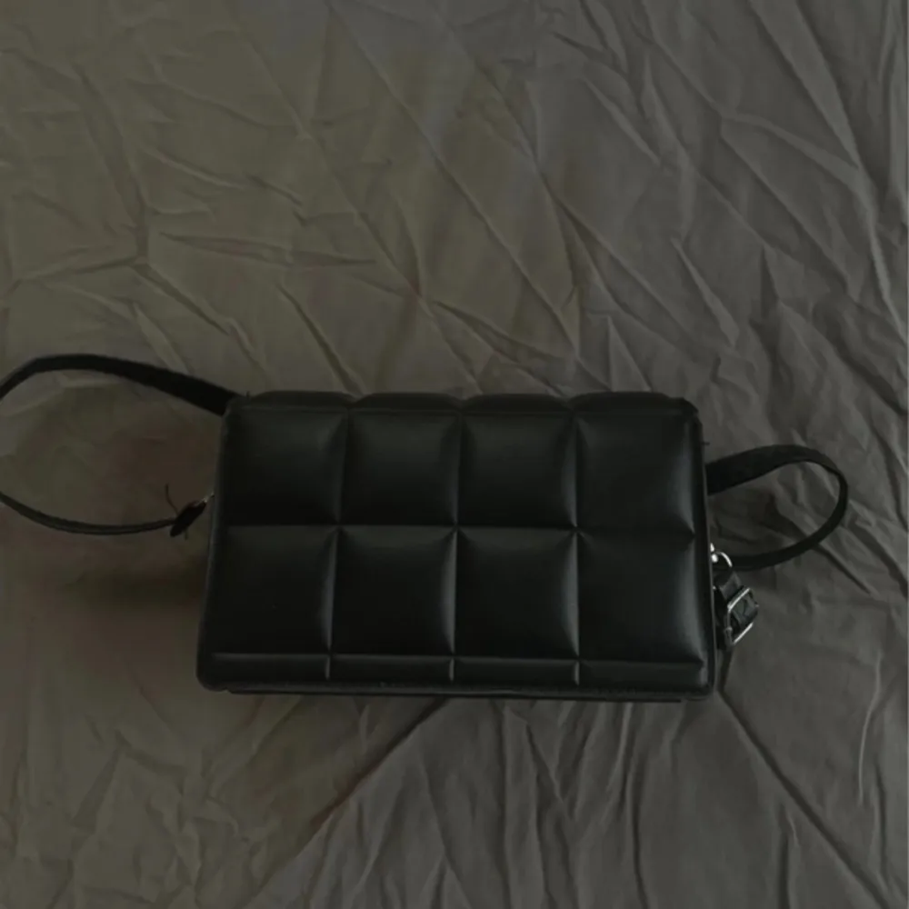 Säljer min stilrena svarta nya väska då den inte kommer till användning, fick denna i present så vet inte vilket märke💘. Väskor.