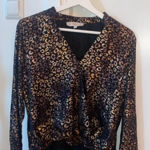 Leopard Satin blus - Satin blus med leopard mönster Kort fram, lång bak.  Super snygg Liten i storlek! L passar S/M