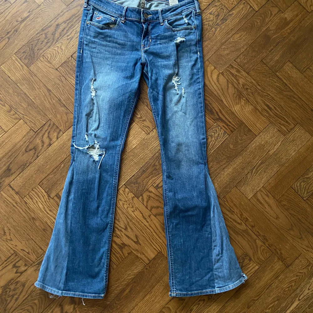 Super trendiga och så unika lågmidjade bootcut jeans från hollister. Omsydda till bootcut. Jeansen är i bra skick förutom små slitningar längst ner på bena. Öppen för byten. Mått i kommentarerna. Första bilden är lånad från förra säljaren. . Jeans & Byxor.