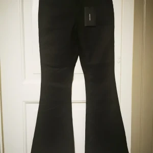 Vaxade, utsvängda byxor  - Nya (med etiketten kvar) vaxade byxor från Vero Moda. Längd 28 tum. Storlek L men något små. Ordinarie pris 399 kr. 