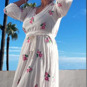 Sommarklänning  - 👗En superfin klänning som får en att drömma om havet. Vit med hand broderade blommor. Har köpt den för 205 euro på Ibiza. Storlek: M/ L 