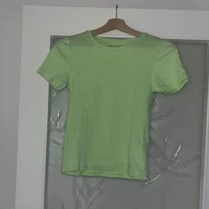 En grön t-shirt, liten i storleken eller kan man ha den som magtröja.