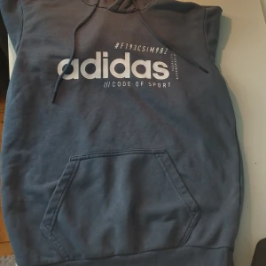 Blå Adidas Hoodie  - En blå Adidas Hoodie i mycket bra skick, inga hål eller märken 👌Storlek S. Perfekt att ha på sig i gymmet, hemma och passar bra till en vit/blå outfit‼️