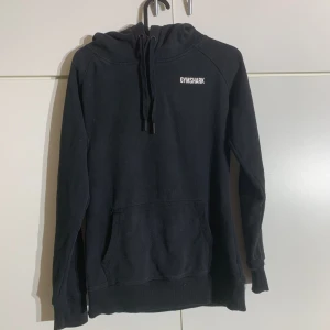 Svart hoodie  - En svart hoodie från gymshark med stor och skön luva. Använd men bra skick. Pris kan diskuteras!