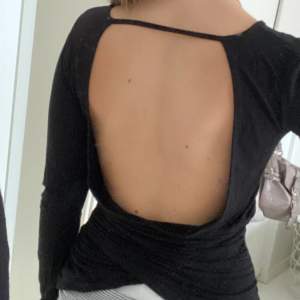 Super snygg vanlig svart tröja med öppen rygg, lite korsat tyg längst ner på ryggen vilket gör den lite mer speciell! Inga defekter!