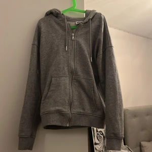 Grå zip-up hoodie - Oanvänd tröja från Urban classics! Inte oversize utan sitter perfekt om man har storlek S i vanligt fall!