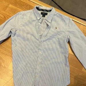 Ralph lauren Skjorta randig - Den är storlek s den är väldigt fin och den har inga håll eller någonting jag säljer den eftersom den är för liten för mig jag väger 70 och är 180 jag skulle säga att den passar mig nästan 