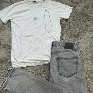 Stone island t-shirt - Säljer nu denna sjuka bundlen för riktigt bra pris! För 299kr får du ett par gråa populära jeans, en ljusgrå tisha från Stone island och ett silver halsband inför sommaren! Finns få defekter som ni kan se på bild 3 och 4 därav priset✔️