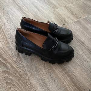 Svarta loafers från MUSK, med detaljkedja i silver och aningen grov/platform sula.  Aldrig använda.