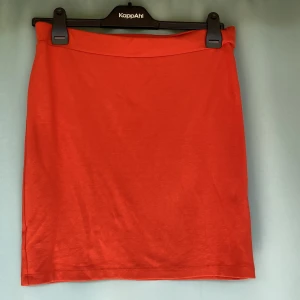 Midikjok  - Kort midikjol i orange färg av 78% viskos  17%polyiester 3% elastisk  Använd ett par gånger.