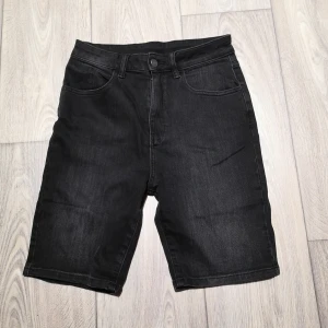 Jeansshorts  - Jeansshorts i något längre modell. Tvättad svart färg. Storlek W28. Stretch. Aldrig använda. 