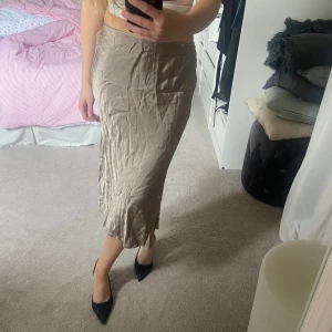 Midi kjol i satin - Minikjol i satin, endast använd en gång. Faller så snyggt när den är stemad, tyvärr lite skrynklig nu. Den är lite beige, metallisk i färgen. Så användbar kjol inför sommaren💕