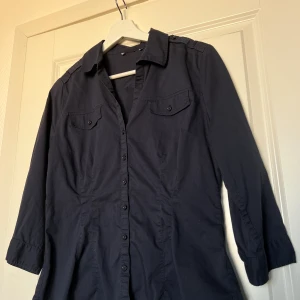 Marinblå H&M skjorta - Fin och sval marinblå trekvarts ärm skjorta från H&M. I bra skick. Storlek 38, normal i storleken. Skulle även passa en storlek 36, med lite lösare passform. Materialet skön och stretchigt. Upphämtning i Malmö möjligt.