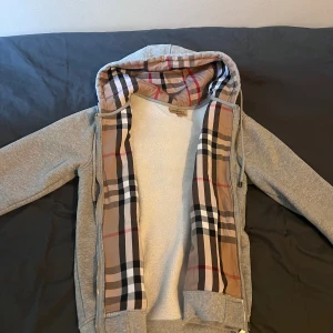 Burberry Zip Hoodie - Säljer nu min Burberry hoodie som jag har haft ett tag. Den säljs för att den inte längre passar mig. Storleken är L men skulle nog passa perfekt på en M. Det finns inga skador eller missfärgningar alls. Mer frågor eller info är det bara att fråga om