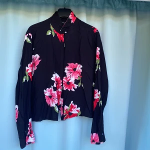 Blus - Långärmad svart blommig blus 100%viskos Andvänd några gånger  Är i bra skick 
