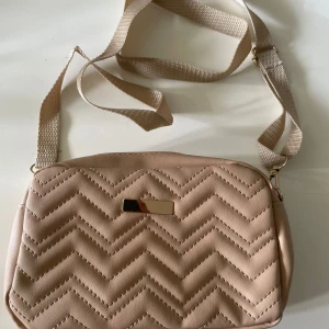 Axelremsväska  - En beige, ganska nude axelremsväska med bra skick