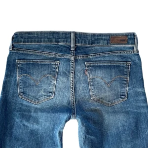 Lågmidjade levi’s bootcut jeans - Lågmidjade utsvängda jeans från levis med jätte cool wash, strl 28/S-M💕 // midja 38cm, längd 98, innerbens 76cm, benöppning 22 // färgen ser mest ut som andra bilden❤️