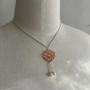 Halsband med blomma - Ett silverhalsband med en blomma🩷 aldrig använd🫶 skriv till mig om fler bilder önskas✨
