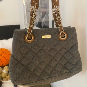 Kate Spade handväska - Skit snygg vardagsväska. Passar även utmärkt som en festväska. Väskan är knappt använd och i nyskick. Blå väska men med bruna läderband. 