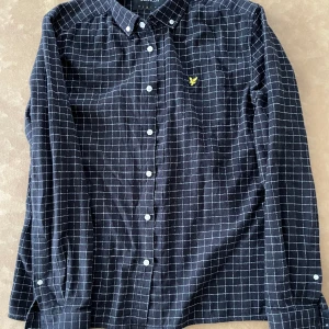 Skjorta - Svart flannelskjorta med rutigt mönster från Lyle & Scott. 100% bomull, storlek M. Mycket fint skick sparsamt använd